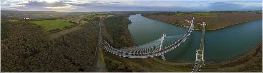 Les 2 ponts de Terenez en soire Le pont de Trnez enjambe l'Aulne entre Argol et Rosnon sur la route dpartementale 791 qui relie Crozon au Faou. Il est situ dans le Finistre et est considr comme un lment essentiel de dsenclavement pour la presqu'le de Crozon, si l'on ne veut pas faire un dtour de 47 km pour passer par Chteaulin afin de rejoindre le Nord-Finistre. Avant la construction du pont, la traverse de l'Aulne se faisait par bacs afin d'assurer la continuit de la route nationale. Les accidents taient trs nombreux, notamment les jours de foire en raison d'un bac   fond plat et peu manoeuvrable qui tait emport par le courant des marres et chaviraient. L'Aulne engloutissait les hommes, les chevaux et les marchandises. Pont de 1925 : Le premier pont de Trnez a t construit entre 1913 et 1925. C'tait un pont suspendu d'une longueur de 350 m, dont 272 m pour la porte principale. Le 13 dcembre 1925, il est ouvert   la circulation et aura t,   l'poque, le plus grand pont d'Europe. Ce pont de Trnez aurait t dtruit le 24 aot 1944 par l'arme allemande, afin de retarder l'avance des troupes allies ; des tmoins affirment qu'il fut dtruit par des bombardements amricains, en mme temps que ceux-ci bombardaient la ville de Telgruc,   proximit. Pont de 1952 : Le nouveau pont, bas sur ses piles d'origine, n'est termin qu'en 1952. C'est un pont suspendu, comme le prcdent, qui reprend les mmes mensurations : longueur de 350 m, dont 272 m pour la porte principale. Ce pont est aujourd'hui atteint du '' cancer du bton '' (alcali-raction) et se trouve depuis 1992 sous troite surveillance. Pont de 2011 : En 1998, le projet retenu s'oriente vers une reconstruction du pont de Trnez   proximit du pont actuel. L'option majeure est d'offrir des accs en courbe pour fluidifier la circulation. Sur le pont de 1951, les accs   angle droit ne permettaient pas le croisement d'un semi-remorque et d'un autre vhicule, l'un devant cder le passage   l'autre. Le chantier a dbut le 19 avril 2007. Les botes d'ancrage des haubans, au sommet des piliers, ont t respectivement hisses le 7 juillet 2009 en rive gauche (ct Argol sur la presqu'le) et le 13 janvier 2010 en rive droite (ct Rosnon). La premire moiti de la structure,   partir du pilier rive gauche, a t acheve fin mars 2010 et l'ensemble de la structure, reliant les deux rives, fin aot 2010. L'inauguration a eu lieu le week-end des 16 et 17 avril 2011 : samedi 16 avril, inauguration et passage symbolique du Tour cycliste du Finistre sur le nouveau pont. Dimanche 17 avril, fermeture totale de l'axe routier avec animations et accs aux deux ponts uniquement rservs aux pitons, cavaliers et vhicules anciens de collection. Ce magnifique ouvrage d'art a ensuite t ouvert dfinitivement   la circulation ce mme jour aux alentours de 23 h. Il est le premier pont courbe   haubans de France, de 515 m de porte dont 285 m pour la trave centrale. L'ouvrage a t conu par l'architecte Charles Lavigne et l'ingnieur Michel Virlogeux. Thomas Lavigne et Christophe Cheron ont assur le suivi architectural de l'ouvrage pendant le chantier. C'est une premire mondiale, jamais un pont   haubans de forme circulaire n'avait t construit. L'ancien pont est inutilis depuis l'ouverture du nouvel ouvrage, il est dcid en 2013 de dtruire l'ancien pont de 1952. Le site tant class Natura 2000, le pont sera dconstruit afin de recycler une partie des matriaux qui le constituent, et d'tudier (dans un laboratoire de Saint-Brieuc) certains lments des pylnes atteints d'alcali-raction. Il sera sci en plusieurs tronons, les deux extrmits du premier pont de 1925 seront conservs et serviront de belvdre. Le chantier doit dbuter le 6 janvier 2014. C'tait pour moi l'occasion de prendre en panoramique arien une dernire fois les deux ponts cte   cte avant la destruction de l'ancien pont. www.360x180.fr Selme Matthieu