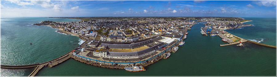 Vue arienne du port de pche du Guilvinec, face  la ct de la pche Haliotika (KAP) Le port du Guilvinec regroupe plusieurs ports du pays bigouden : Le Guilvinec, Saint-Gunol, Bnodet, Loctudy et Lesconil. Ce regroupement est le plus important de France, que l'on prenne en compte le nombre de marins (environ 1000 marins) ou la valeur de la marchandise vendue (3000 emplois crs grce  la filire pche, entre les cries, les entreprises de mareyage, les chantiers navals, les conserveries, les avitailleurs... ). Cet ensemble de port reprsente en production presque 20% de la pche franaise ! Si l'on observe attentivement l'image, on aperoit au dessus de la ligne bleue une foule de touristes : en fait, on est au dessus de la crie et de la zone de dbarquement, et on observe alors le mange des petites grues qui dbarquent le poisson, sans embter ni gner les pcheurs !  www.360x180.fr Selme Matthieu