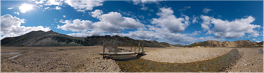 Landmannalaugar : pont enjambant la rivire Graenagil C'est avec beaucoup de joie et d'excitation que nous prenons le bus de Reykjavik vers Landmannalaugar. J'admire le paysage et j'essaie de ne pas louper une miette du spectacle que la nature m'offre. Plus nous nous rapprochons et plus je reconnais ce paysage vallonn sans arbre qui ressemble  un dsert de dunes de sable auquel on aurait rajout toutes les couleurs de l'arc-en-ciel : de l'ocre de la terre volcanique au vert de la mousse qui y pousse. Pour notre plus grande joie, ces couleurs sont sublimes par le bleu du ciel. Nous arrivons vers 12h, plantons notre tente, djeunons et dcidons de partir pour une petite rando avec sac lger  la demi-journe.  www.360x180.fr Selme Matthieu